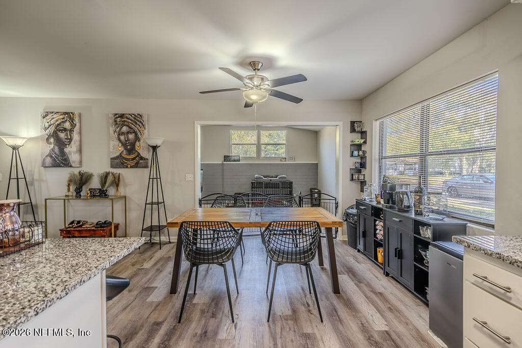 7580 Strato Road Jacksonville, FL 32210 - Photo 9 of 27 a kitchen with stainless steel appliances granite countertop a stove a sink dishwasher a dining table and chairs with wooden floor