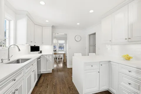 a kitchen with white cabinets and appliances