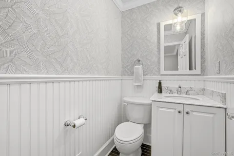 a bathroom with a granite countertop toilet sink and mirror