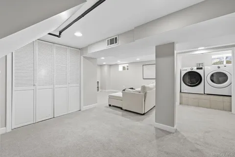 a living room with furniture and a refrigerator