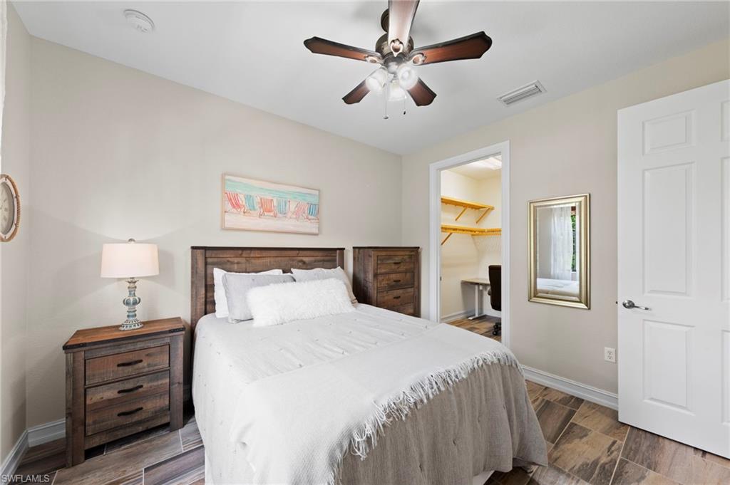 9076 Rialto Street, Unit 6204 Naples, FL 34113 - Photo 22 of 50 Secondary bedroom featuring wood-finish tile flooring, a ceiling fan with integrated lighting, WALK-IN CLOSET and neutral wall tones. NEW TILE FLOOR (2018)