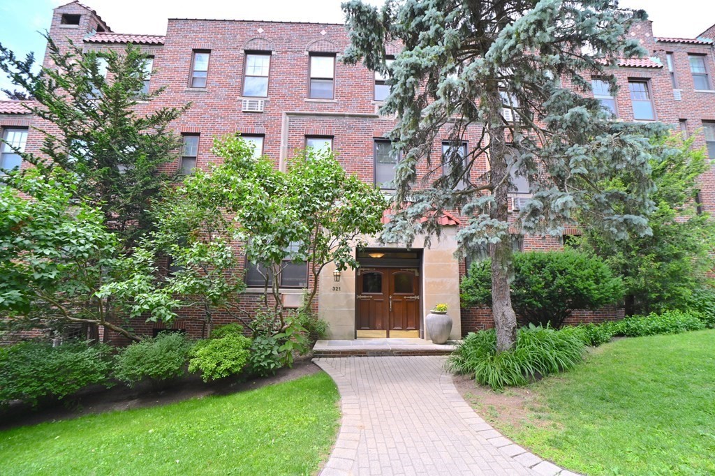 321 Tappan Street, Unit 6 Brookline, MA 02445 - Photo 13 of 14 a front view of a house with yard and green space