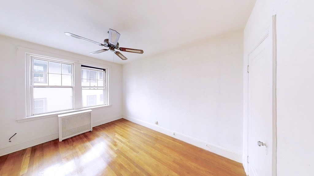 321 Tappan Street, Unit 6 Brookline, MA 02445 - Photo 5 of 14 an empty room with wooden floor and windows