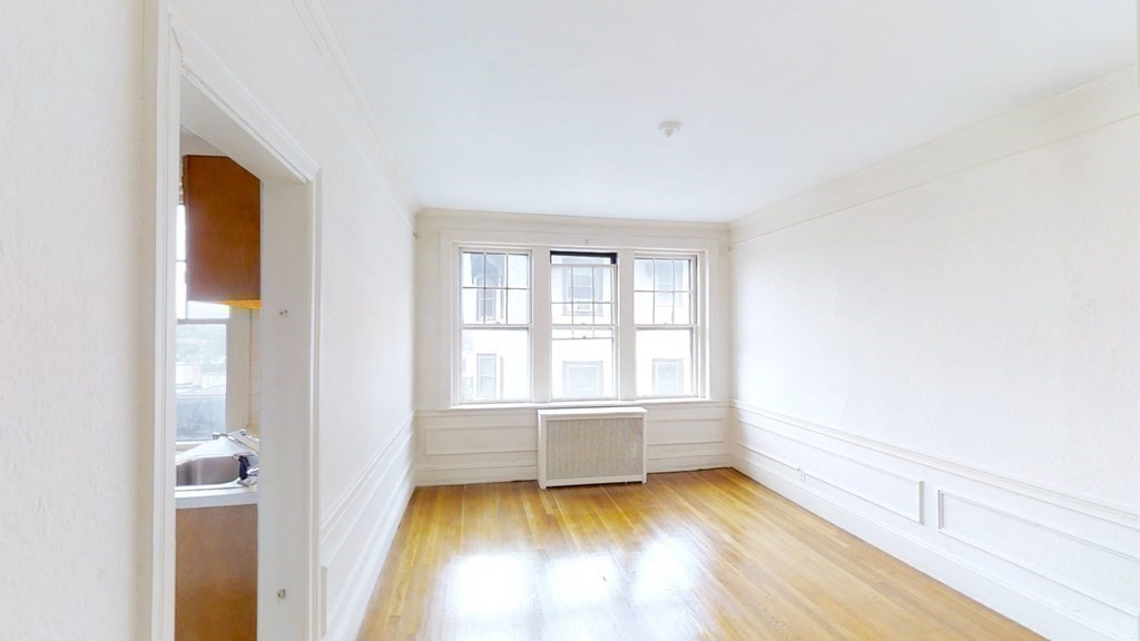 321 Tappan Street, Unit 6 Brookline, MA 02445 - Photo 7 of 14 a view of an empty room with a window and wooden floor