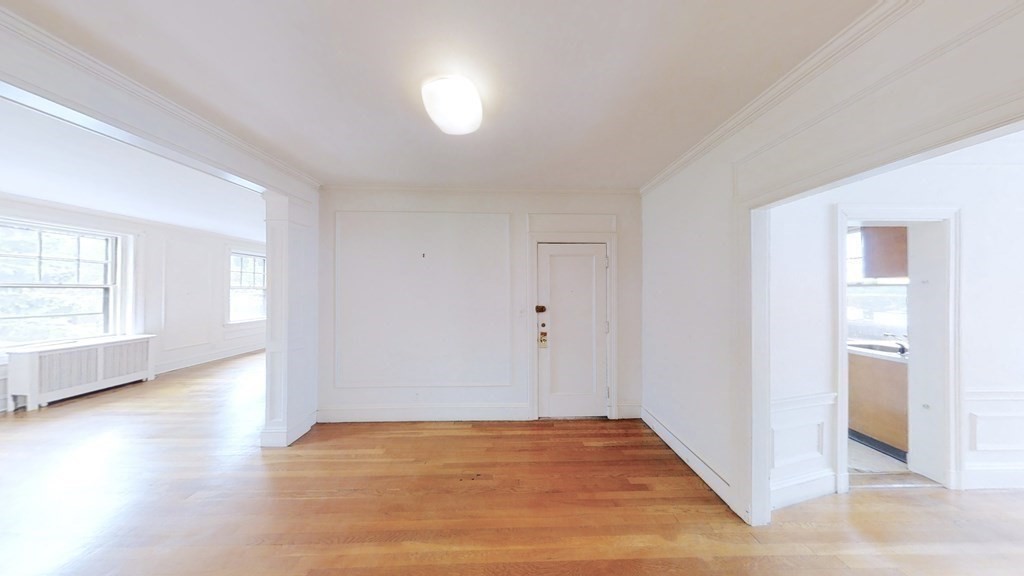 321 Tappan Street, Unit 6 Brookline, MA 02445 - Photo 8 of 14 an empty room with wooden floor and windows