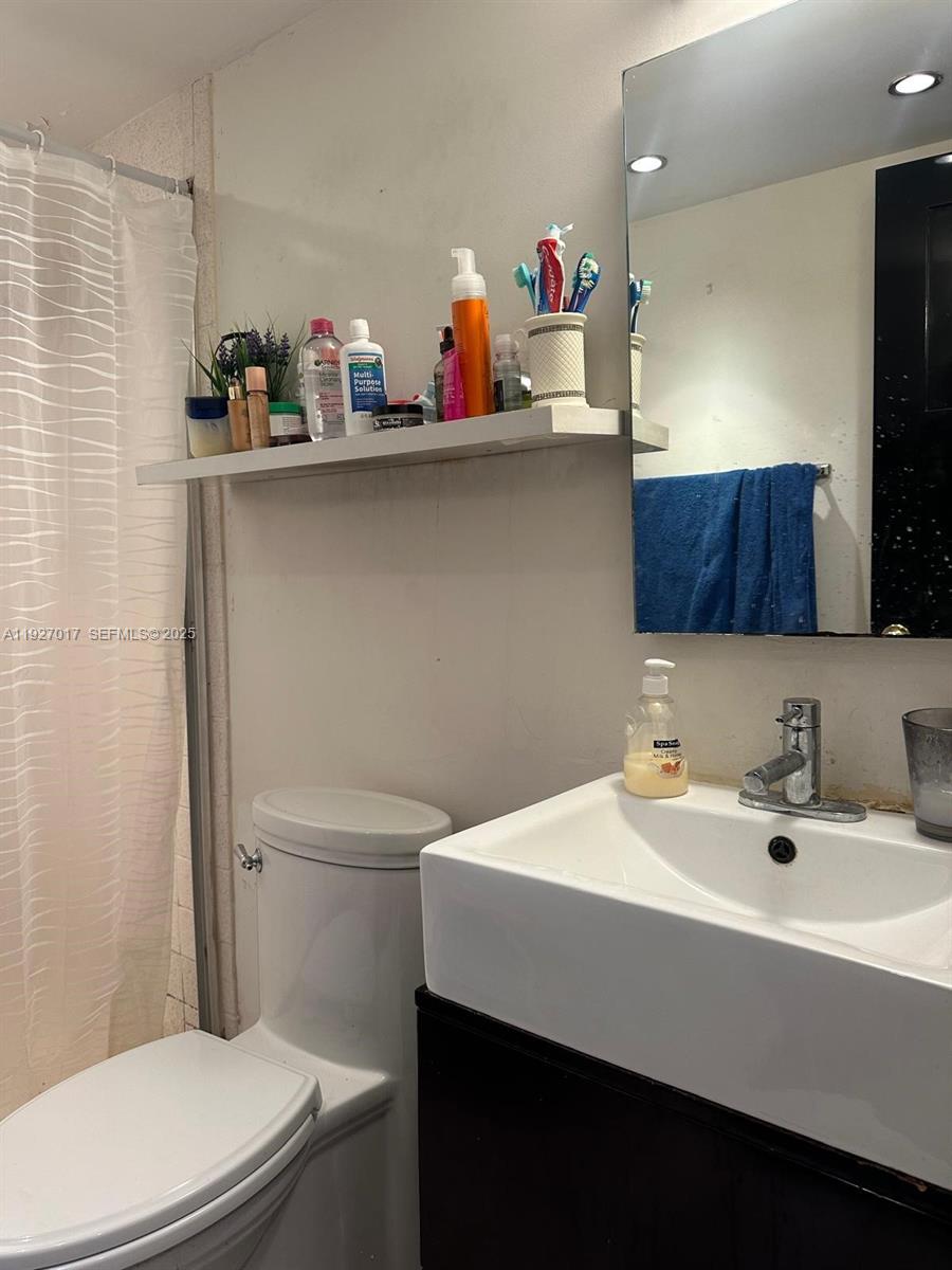 600 Northeast 36th Street, Unit 701 Miami, FL 33137 - Photo 15 of 19 a bathroom with a sink a toilet and a mirror
