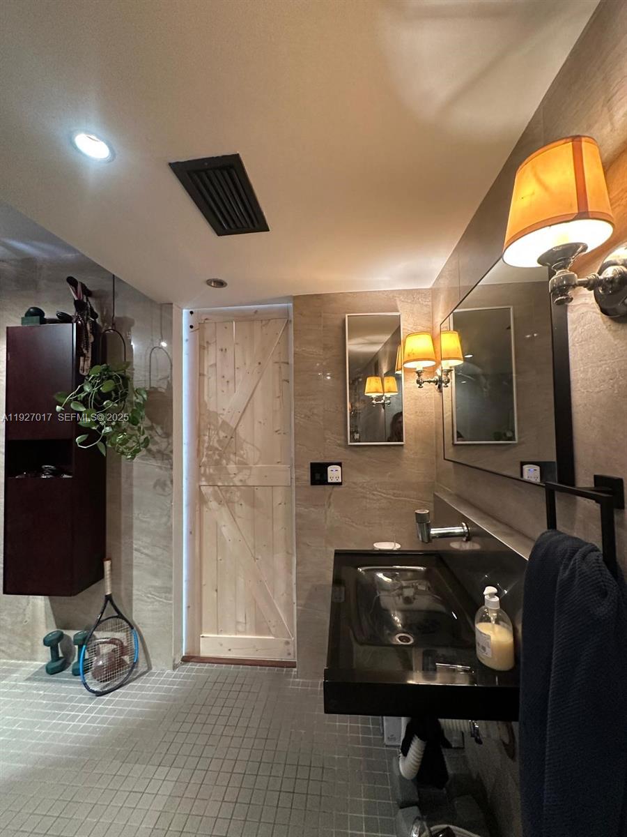 600 Northeast 36th Street, Unit 701 Miami, FL 33137 - Photo 17 of 19 a room with gym equipment and a mirror