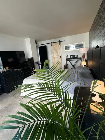 a bedroom with a bed and flat screen tv