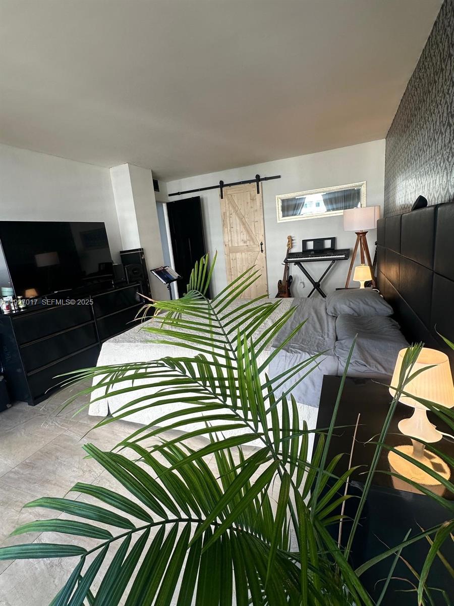 600 Northeast 36th Street, Unit 701 Miami, FL 33137 - Photo 2 of 19 a bedroom with a bed and flat screen tv