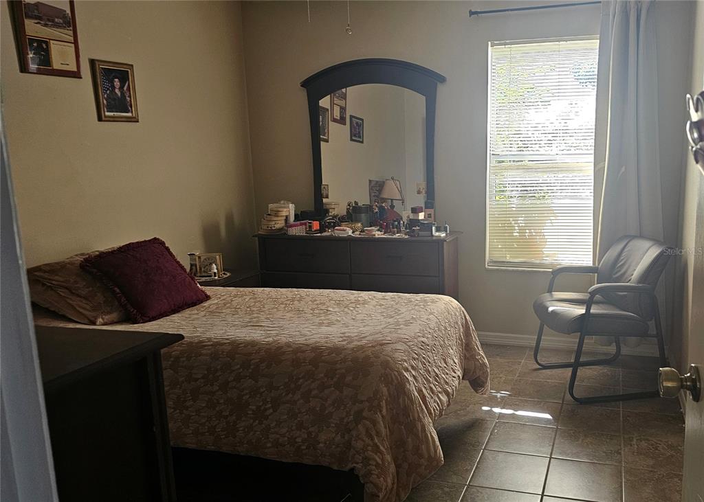 9906 Surrey Ridge Road Orlando, FL 32825 - Photo 11 of 18 a bedroom with a bed and a window