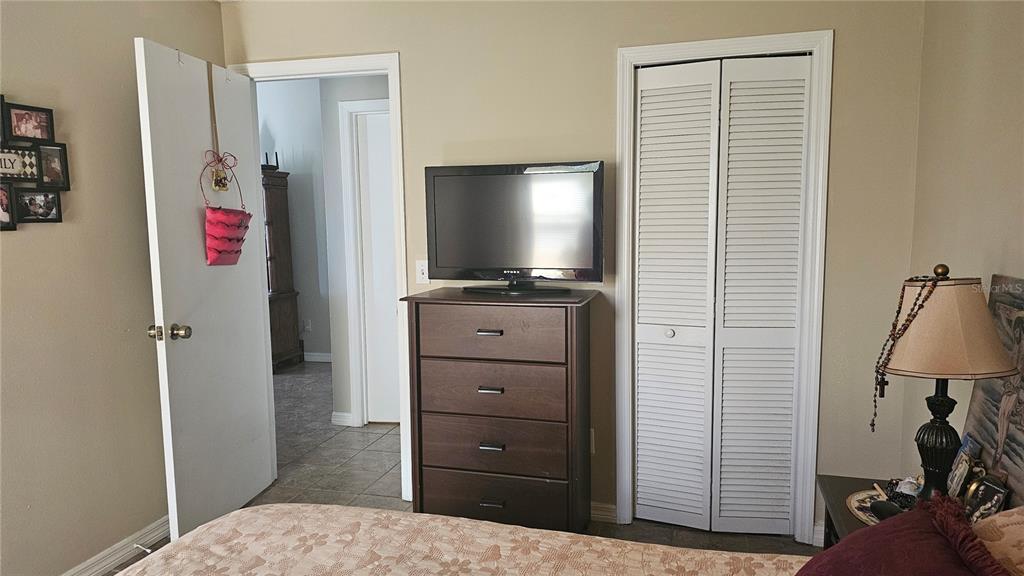 9906 Surrey Ridge Road Orlando, FL 32825 - Photo 13 of 18 a view of a bedroom with baby bed and workspace