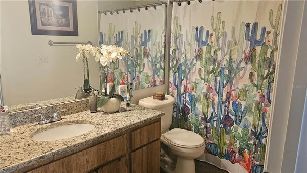 a bathroom with a granite countertop sink and a toilet