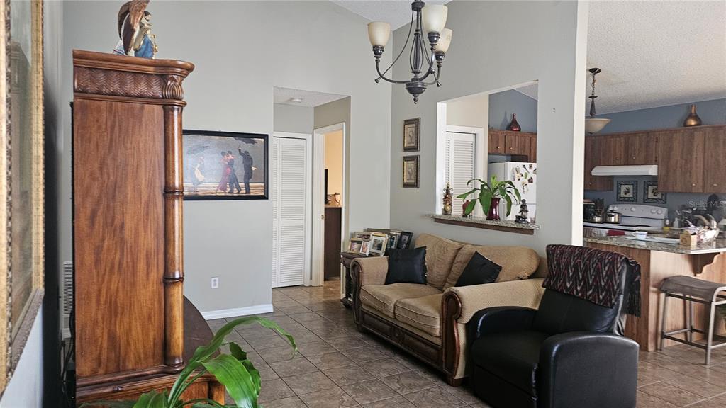 9906 Surrey Ridge Road Orlando, FL 32825 - Photo 3 of 18 a living room with furniture and a chandelier