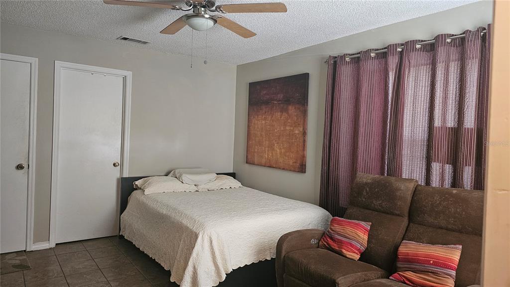 9906 Surrey Ridge Road Orlando, FL 32825 - Photo 6 of 18 a bedroom with a bed window and couch