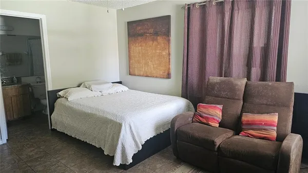 a bedroom with bed couch and window