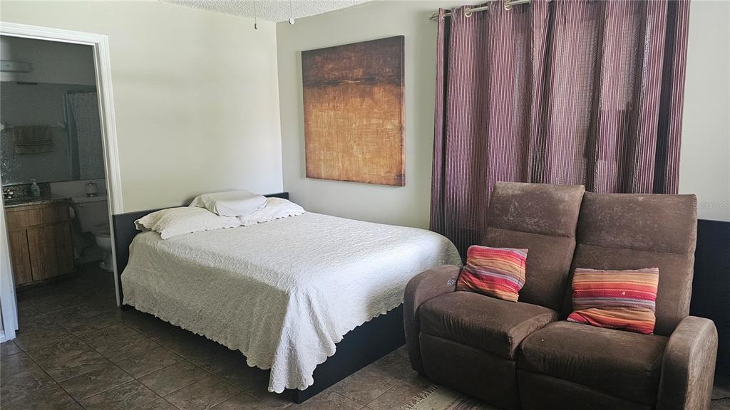 9906 Surrey Ridge Road Orlando, FL 32825 - Photo 7 of 18 a bedroom with bed couch and window