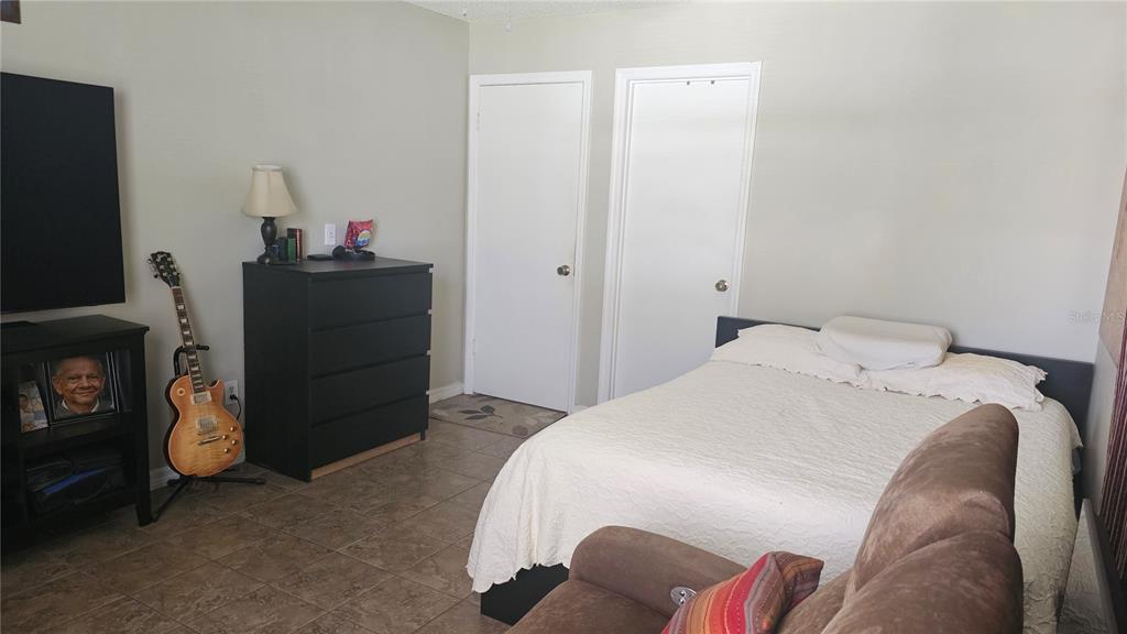 9906 Surrey Ridge Road Orlando, FL 32825 - Photo 9 of 18 a bedroom with a bed and a tv in it