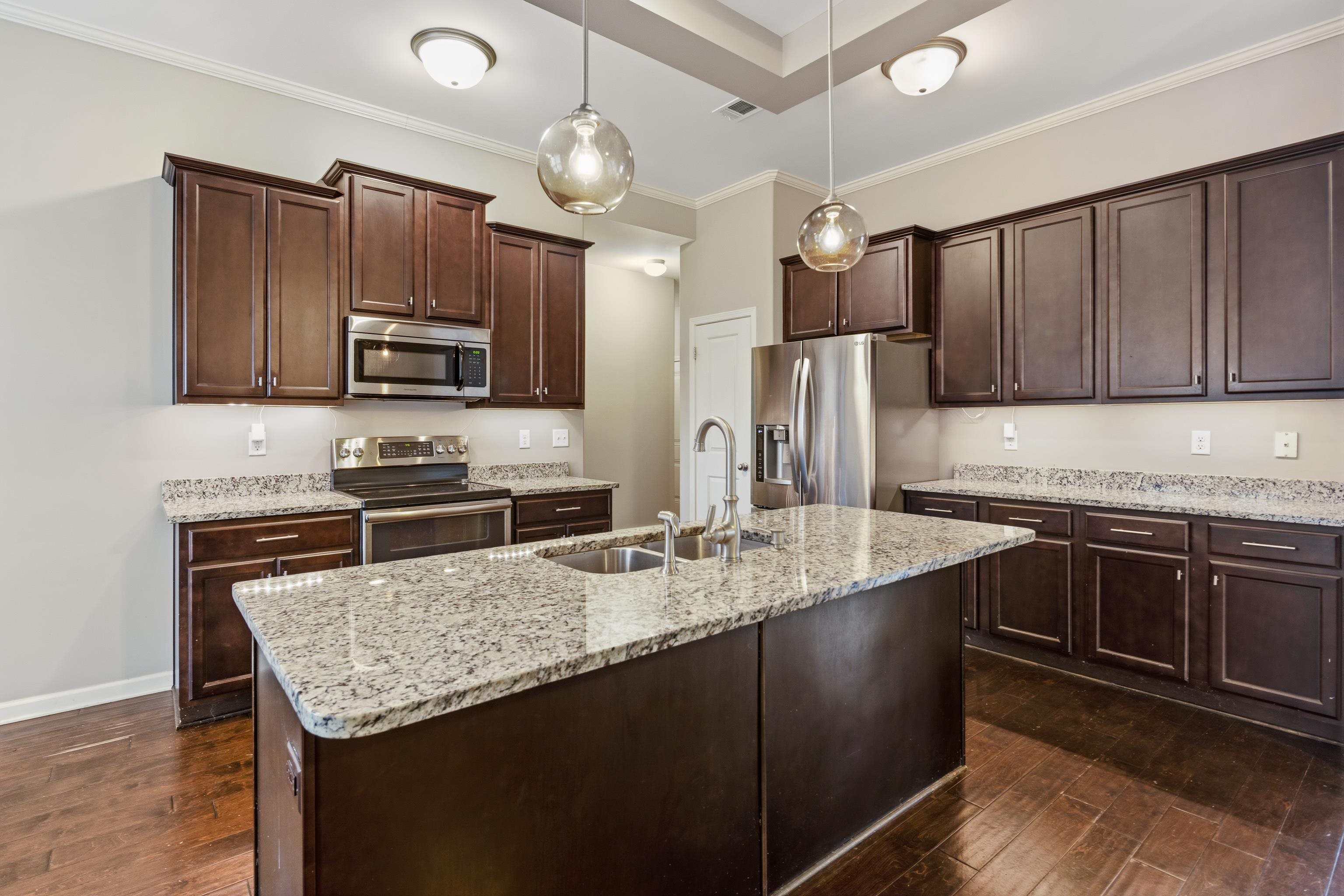 7313 Shadow Run Lane Bartlett, TN 38002 - Photo 13 of 40 a kitchen with stainless steel appliances granite countertop a sink stove and refrigerator