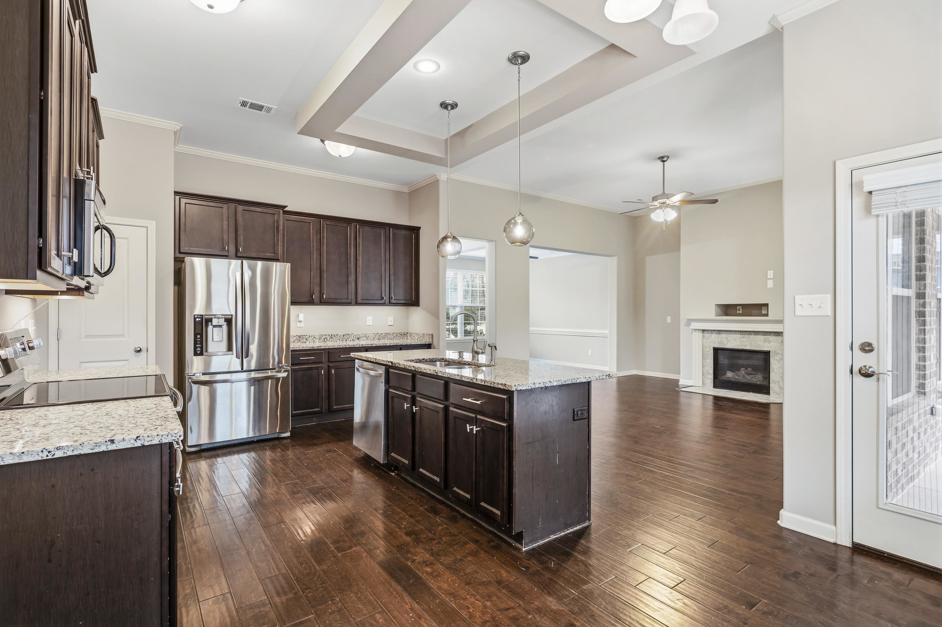 7313 Shadow Run Lane Bartlett, TN 38002 - Photo 14 of 40 a large kitchen with cabinets wooden floor and stainless steel appliances