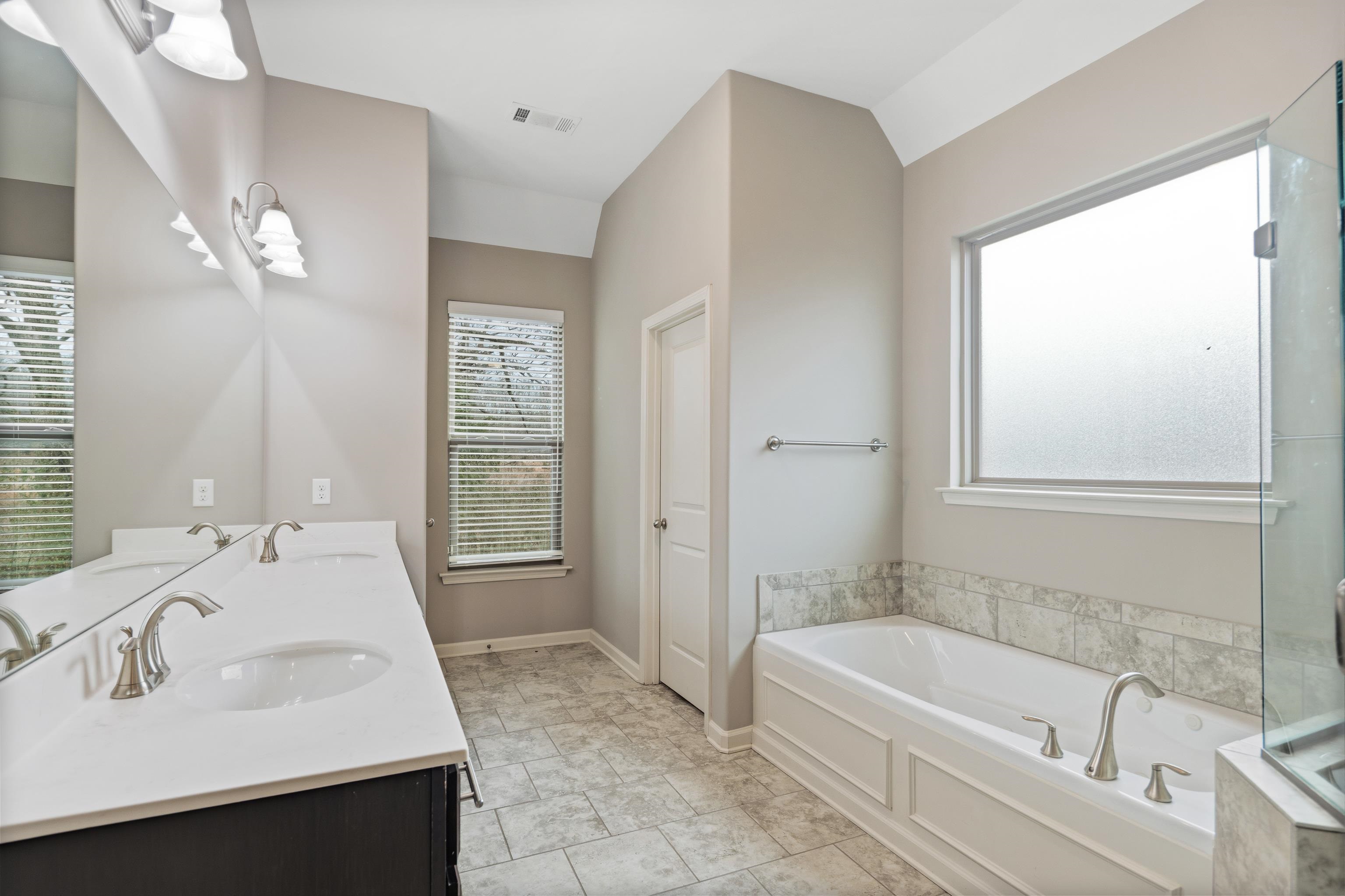 7313 Shadow Run Lane Bartlett, TN 38002 - Photo 18 of 40 a bathroom with a bathtub sink and mirror