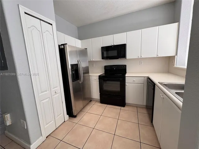 a kitchen with stainless steel appliances a refrigerator sink and microwave