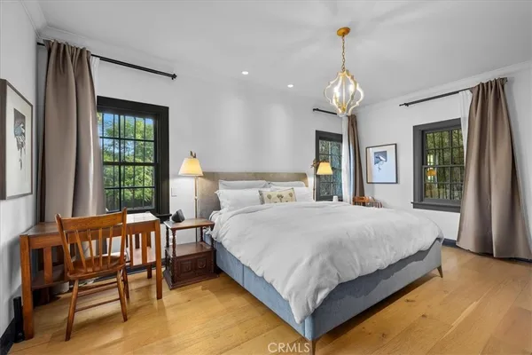 a spacious bedroom with a bed chandelier and a window