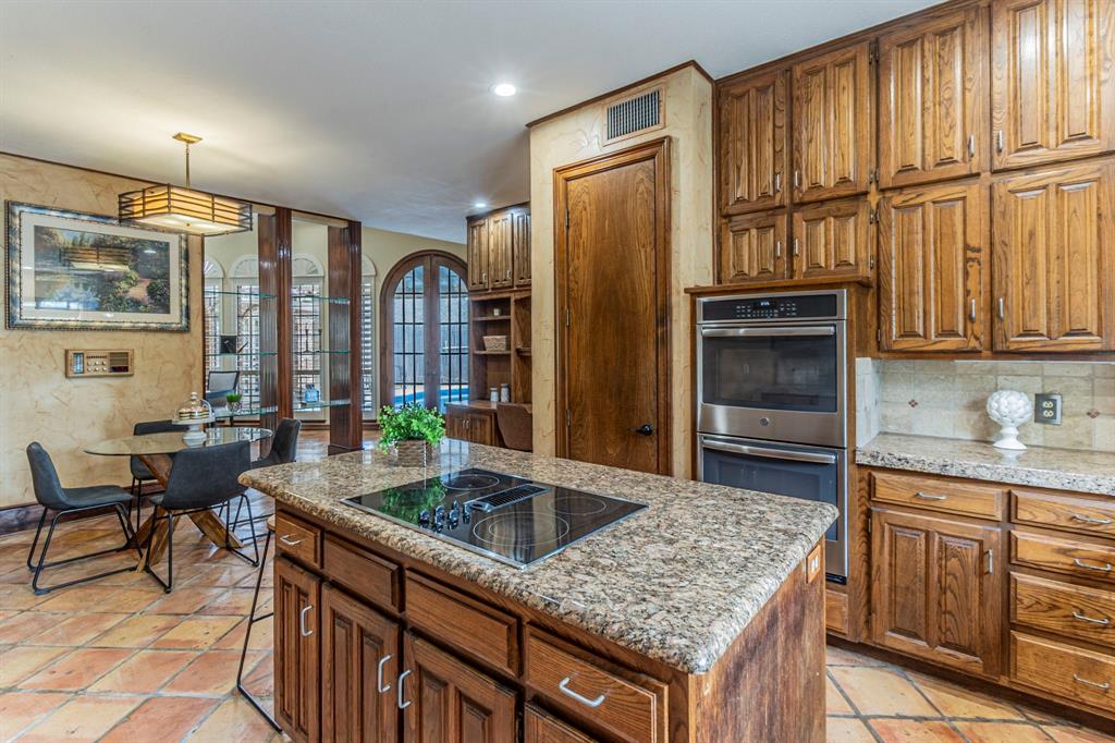 2714 Ridge Top Lane Arlington, TX 76006 - Photo 11 of 37 Kitchen featuring stainless steel double oven, a kitchen island, wood finish cabinetry, and black electric stovetop