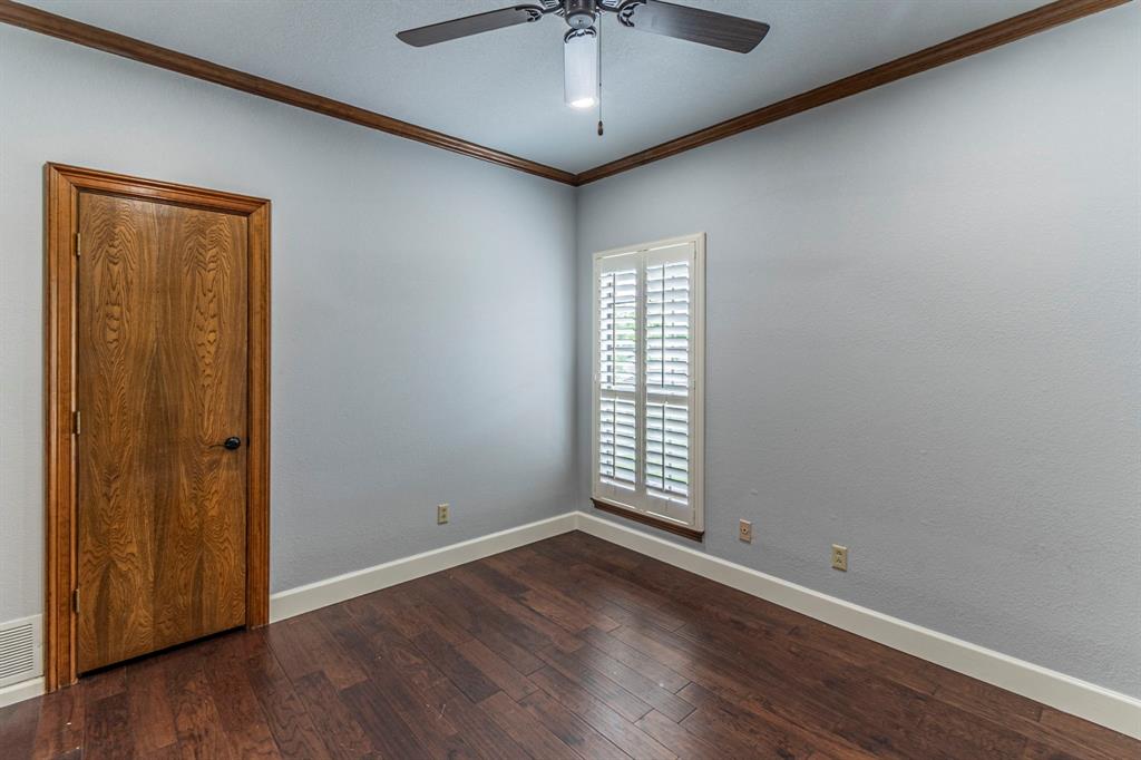 2714 Ridge Top Lane Arlington, TX 76006 - Photo 30 of 37 Empty room featuring ceiling fan, dark wood-style floors, and crown molding