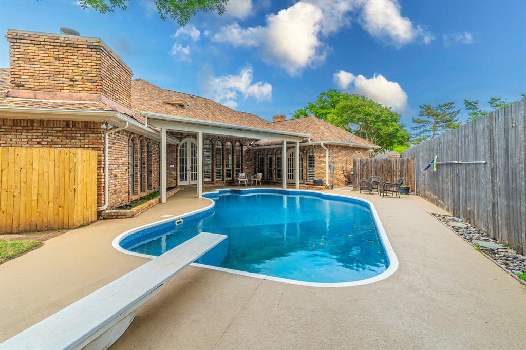2714 Ridge Top Lane Arlington, TX 76006 - Photo 34 of 37 View of swimming pool featuring patio surround, a diving board, a fenced backyard, and french doors