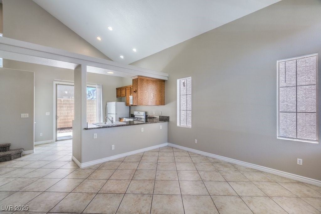 8121 Altamont Ridge Street Las Vegas, NV 89113 - Photo 6 of 27 Kitchen featuring high vaulted ceiling, brown cabi