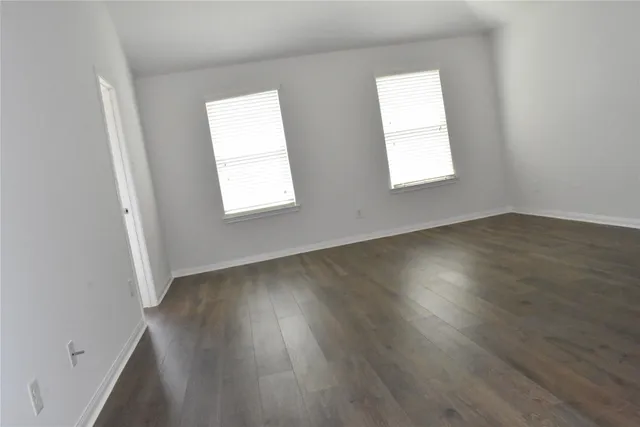 a view of an empty room with wooden floor