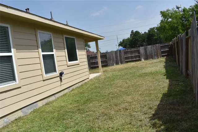a view of backyard with wooden fence