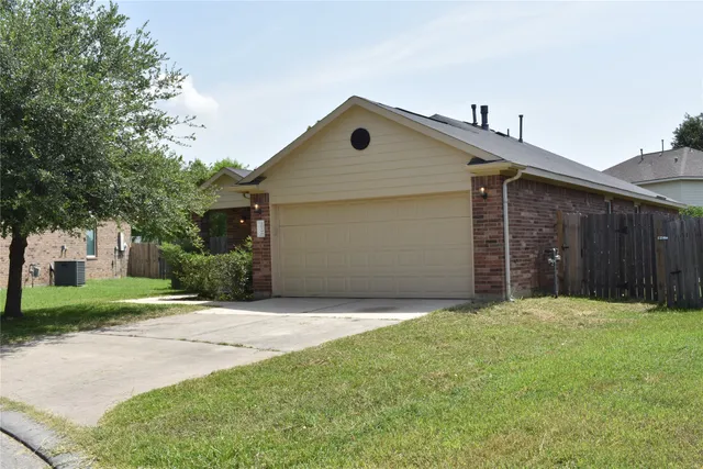 a front view of house with yard and trees in the background