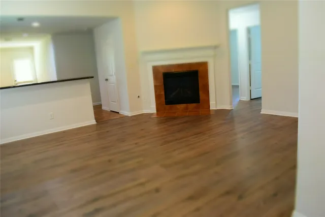 a view of empty room with wooden floor and fireplace