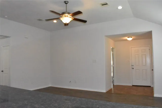 an empty room with a empty space and a ceiling fan