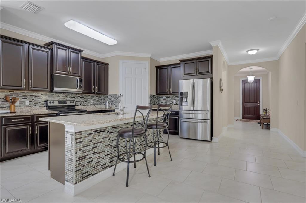 16309 Aberdeen Way Naples, FL 34110 - Photo 6 of 34 a kitchen with stainless steel appliances a refrigerator stove microwave and sink