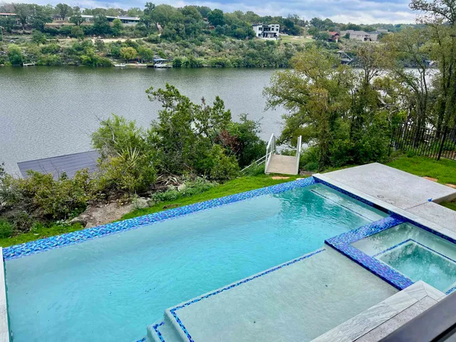 an aerial view of a house with a yard and lake view