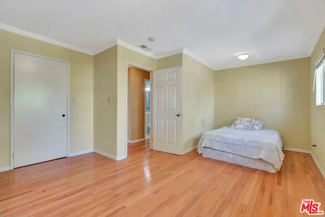 a spacious bedroom with a bed and a dresser