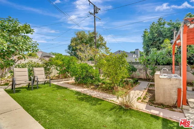 a patio with table and chairs and potted plants