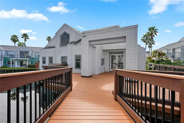 a view of a house with large windows and a wooden deck