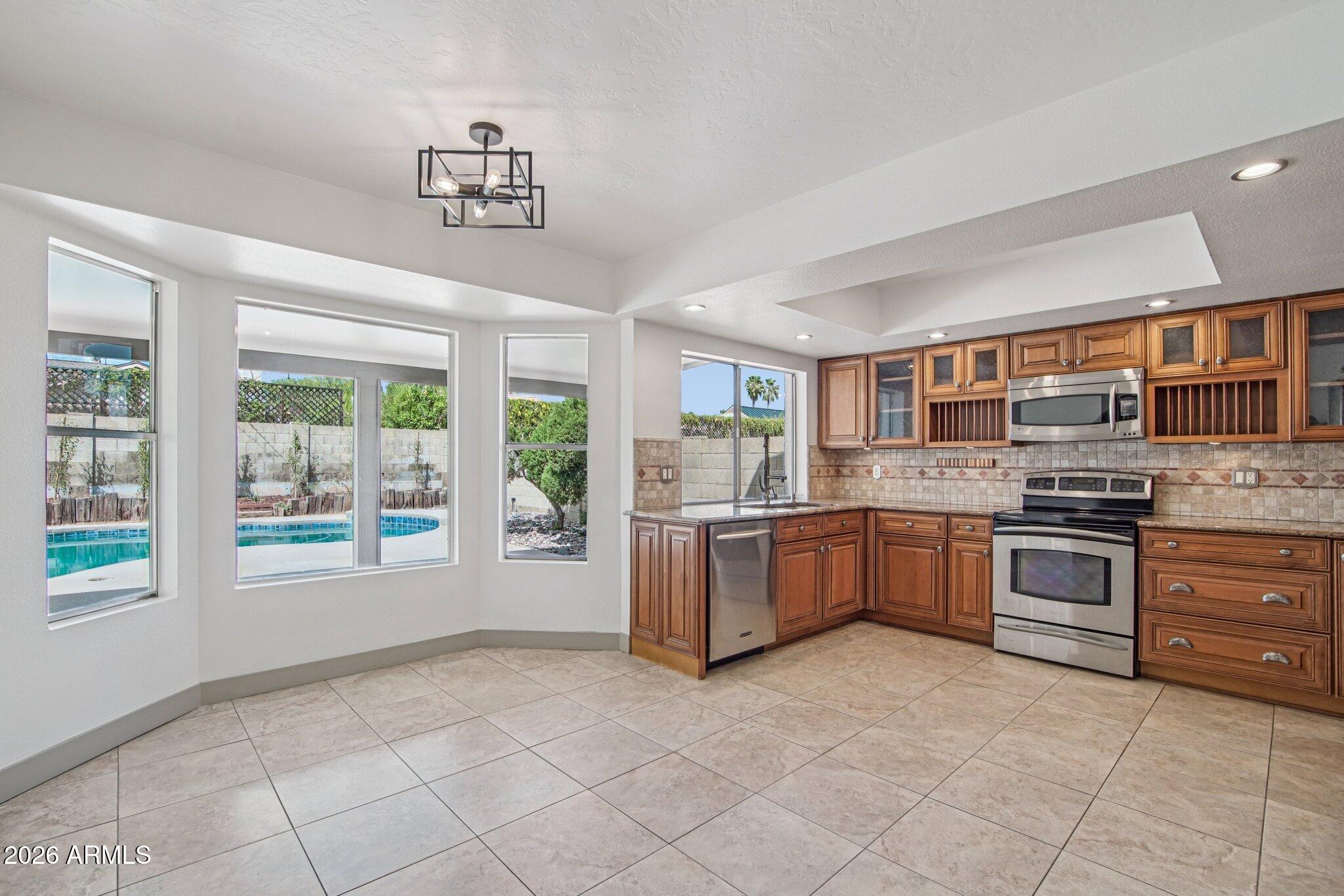 4662 East Grandview Road Phoenix, AZ 85032 - Photo 17 of 42 a large kitchen with a stove a sink dishwasher and a stove