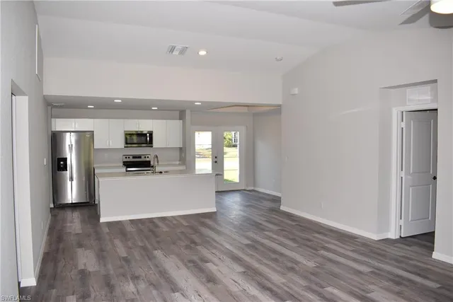 a view of kitchen with stainless steel appliances kitchen island wooden floors and stove