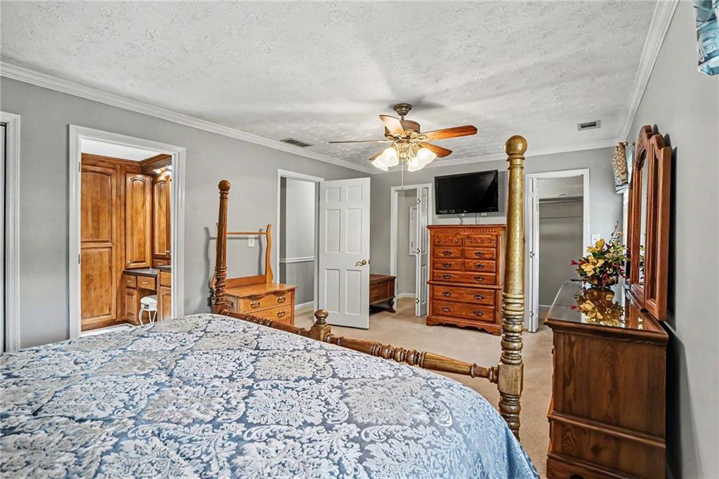 740 Smyrna Road Southwest Conyers, GA 30094 - Photo 14 of 27 a bedroom with a bed dresser and a flat tv screen