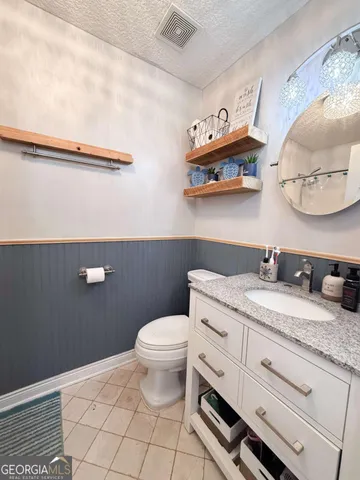 a bathroom with a granite countertop sink a toilet and a mirror