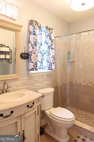 a bathroom with a sink toilet and shower