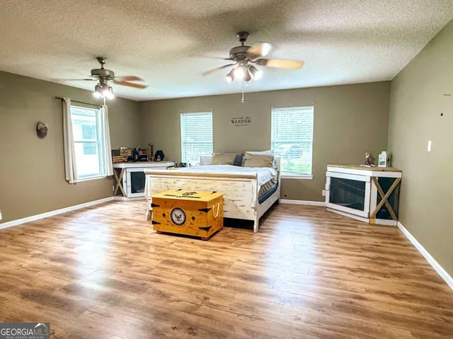 a spacious bedroom with a bed and a chandelier