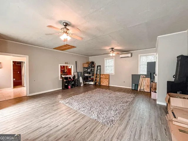 a view of a livingroom with wooden floor and a ceiling fan