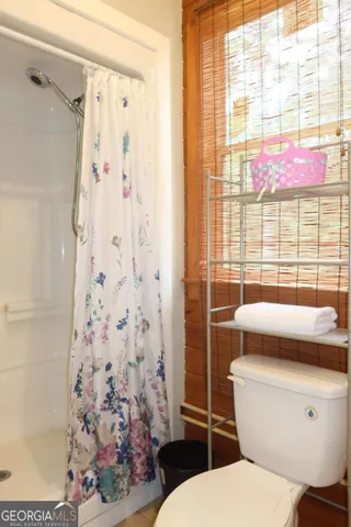 a bathroom with a toilet and a shower curtain