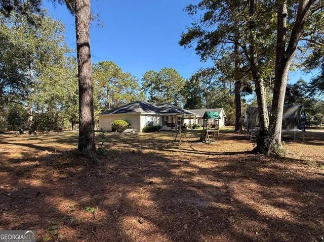 a front view of a house with a yard and trees