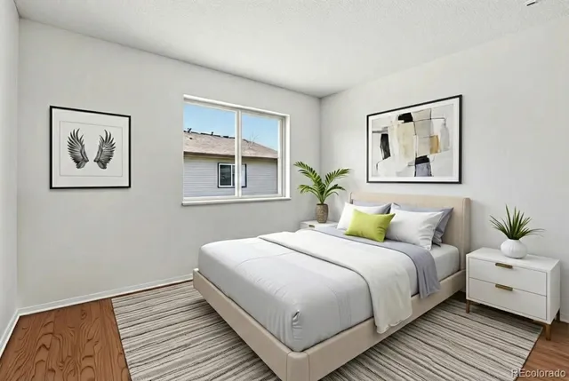 a bedroom with a large bed and a painting on the wall